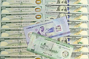 UAE new 50 dirham and new 10 dirham polymer bank notes over a new US 100 dollar bills