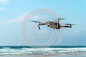 UAV Drone Quadcopter And Digital Camera Flying On Beach