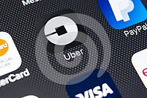Uber application icon on Apple iPhone X screen close-up. Uber app icon. Uber is taxi car transportation application.