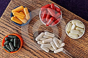 Ubiquinol coQ10 coenzyme q10, chlorophyll, n-acetyl cysteine NAC, l-lipoic acid and b-complex supplements on wooden board. photo