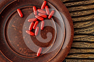 Ubiquinol coQ10 coenzyme q10 supplement softgels on a clay plate. immune prevention care concept photo