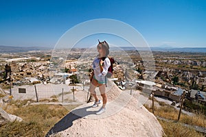 Uchisar Castle. Tourist at the top of the fortress, mountains, view of Cappadocia. Girl Traveler at Destinaton. Turkey Vacation