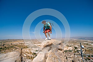 Uchisar Castle. Tourist at the top of the fortress, mountains, view of Cappadocia. Man photographer, male Traveler at Destinaton.