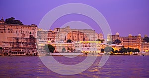 Udaipur Lal ghat, houses and City Palace on bank of lake Pichola with water riffles. Rajasthan. Sunset at Udaipur, India