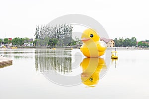 Ellow giant inflatable duck and yellow boat on the lake in Nong Prajak Park, Udon Thani
