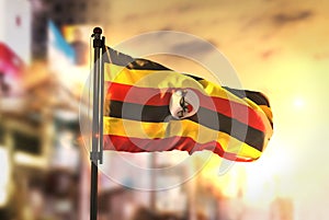 Uganda Flag Against City Blurred Background At Sunrise Backlight