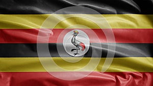 Ugandan flag waving in the wind. Close up of Uganda banner blowing soft silk