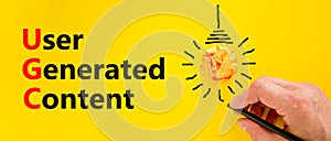 UGC user generated content symbol. Concept words UGC user generated content on a beautiful yellow background. Orange light bulb