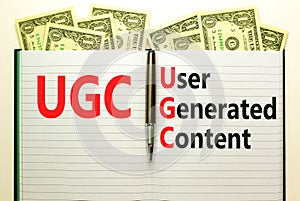 UGC user generated content symbol. Concept words UGC user generated content on white note on a beautiful background from dollar