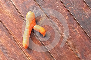 Ugly carrot on wooden table. Food waste reduce concept.
