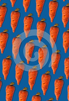 Ugly carrots regular pattern with shadows pastel background. Big deformed vegetables on pastel background.Trendy flatlay