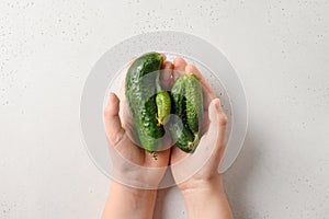 Ugly cucumbers in child hands. Concept organic vegetables. View from above