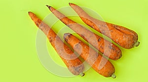 Ugly food. Deformed carrots on trendy yellow background. Food waste problem concept.Minimal flatlay,pop art style