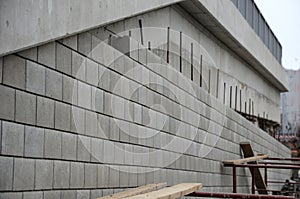 Ugly holding a road notch of a bridge forecourt tunnel. retaining wall with concrete grouting is covered with fake, optically pret