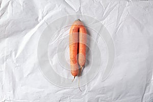 Ugly misshapen carrots on craft paper background. Concept of zero waste production. Top view. Copy space. Non gmo vegetables