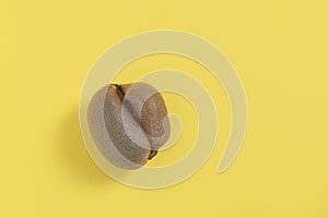 Ugly misshapen fruit kiwi on yellow background