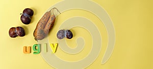 Ugly plums and carrot on yellow background. fruits are suitable for food. Concept Reduction of organic food waste. Copy