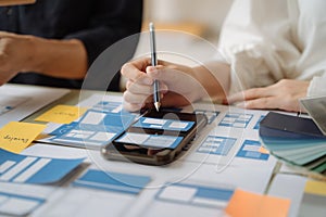 UI developer and ui designer brainstorming about mobile app interface wireframe design with customer breif and color code at