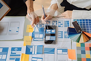 UI developer and ui designer brainstorming about mobile app interface wireframe design with customer breif and color code at