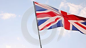 UK British flag waving in cloudy blue sky
