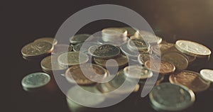 UK Currency pounds coins rotating amongst other UK currency coins in 4K.