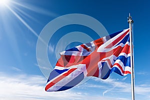 UK Flag Blowing in the Wind on Blue Sky with Clouds - Union Jack Flag