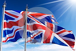 UK Flags Blowing in the Wind on Blue Sky with Clouds - Union Jack Flag