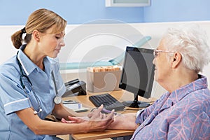 UK nurse injecting senior woman patient photo