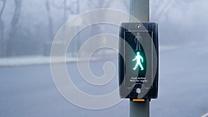 UK traffic crossing with Green man Illuminated on a cold foggy day