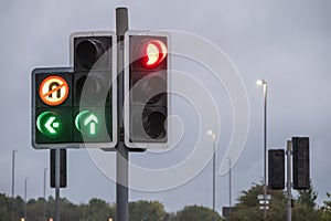 UK traffic lights at dawn against grey sky with LED streetlights in background