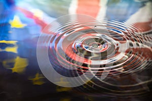 UK Union Jack and European Union EU flags reflected in water splash with a drop of water falling