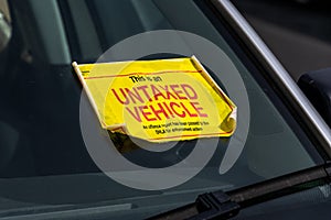 UK Untaxed Vehicle sticker on the windscreen of a parked car