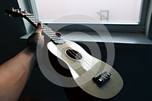 ukelele on hand whit a soft light