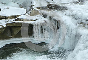 Ukraine, Carpathians, frozen alpine river with waterfall