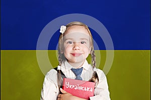 Ukraine concept with kid little girl student with red book on the Ukraine flag background. Learn ukrainian language