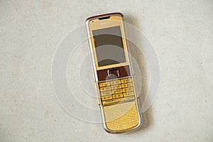 Ukraine Dnepr 19.08.2021 - Nokia 8800 gold lies on gray light paper, old phone, mobile