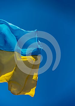 Ukraine flag large national symbol fluttering in blue sky. Large yellow blue Ukrainian state flag