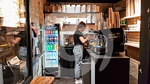 Ukraine, Kiev - March 06, 2020. Prepare a work order concept. Barista girl makes coffee. Cafe and counter with coffee equipment,