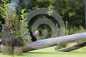 Ukraine, Kyiv, August 25, 2018: A young guy makes a landscape photographing camera Kenon. Removes a small swamp in the forest