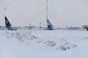 Ukraine, Kyiv - February 12, 2021: Planes at Winter. Aircraft. There is a lot of snow at the airport. Bad weather and visibility.