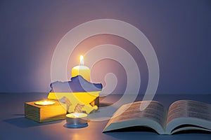 Ukraine map and Holy Bible with candle lighting on colored background. Pray for Ukraine concept