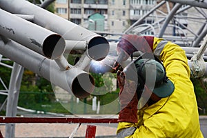 Welding works on welding of metal structures. An electric welder works on scaffolding.