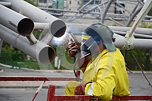 Welding works on welding of metal structures. An electric welder works on scaffolding.