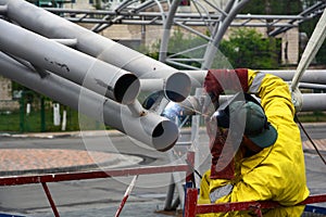 Welding works on welding of metal structures. An electric welder works on scaffolding.