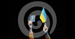 Ukraine national flag on a stick and state biometric passport in hands. Symbol of Ukrainian statehood. Copy space