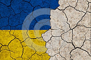 Ukraine national flags grunge pattern on grungy dry cracking parched earth. Cracked soil