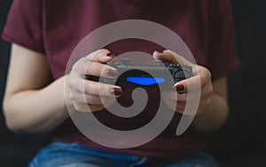 Ukraine, Odessa - July 2, 2019: A girl plays a video game on a playstation 4 joystick. The ps4 gamepad is in the girlÃ¢â¬â¢s hands.