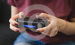 Ukraine, Odessa - July 2, 2019: A girl plays a video game on a playstation 4 joystick. The ps4 gamepad is in the girlÃ¢â¬â¢s hands.