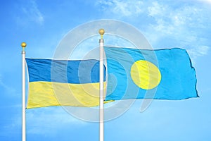 Ukraine and Palau two flags on flagpoles and blue sky