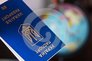 Ukraine, passporton the background of the globe. Ukrainian passports in hands are on the world map. Travel concept